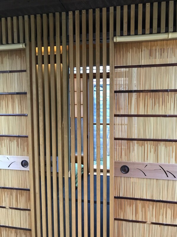 A wooden gate with vertical slats and a window in the center.