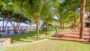 Ein tropisches Resort mit Poolbereich, Liegestühlen und Meerblick.