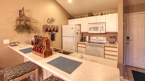 A compact kitchen with a central island, a refrigerator, microwave, and a stove.