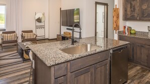 A modern kitchen with granite countertops, a stainless steel sink, and dark wood cabinets. - Brand New Townhome - 10 Minutes from Downtown (Bozeman)