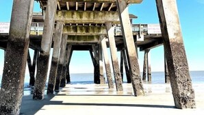 Un muelle con pilares de madera que sostienen un balcón.