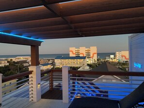 Un balcon donnant sur une zone côtière, avec vue sur des bâtiments et une plage.