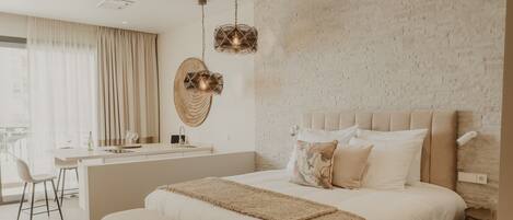 A modern bedroom with a large bed, bedside tables, a bench, and a desk area.