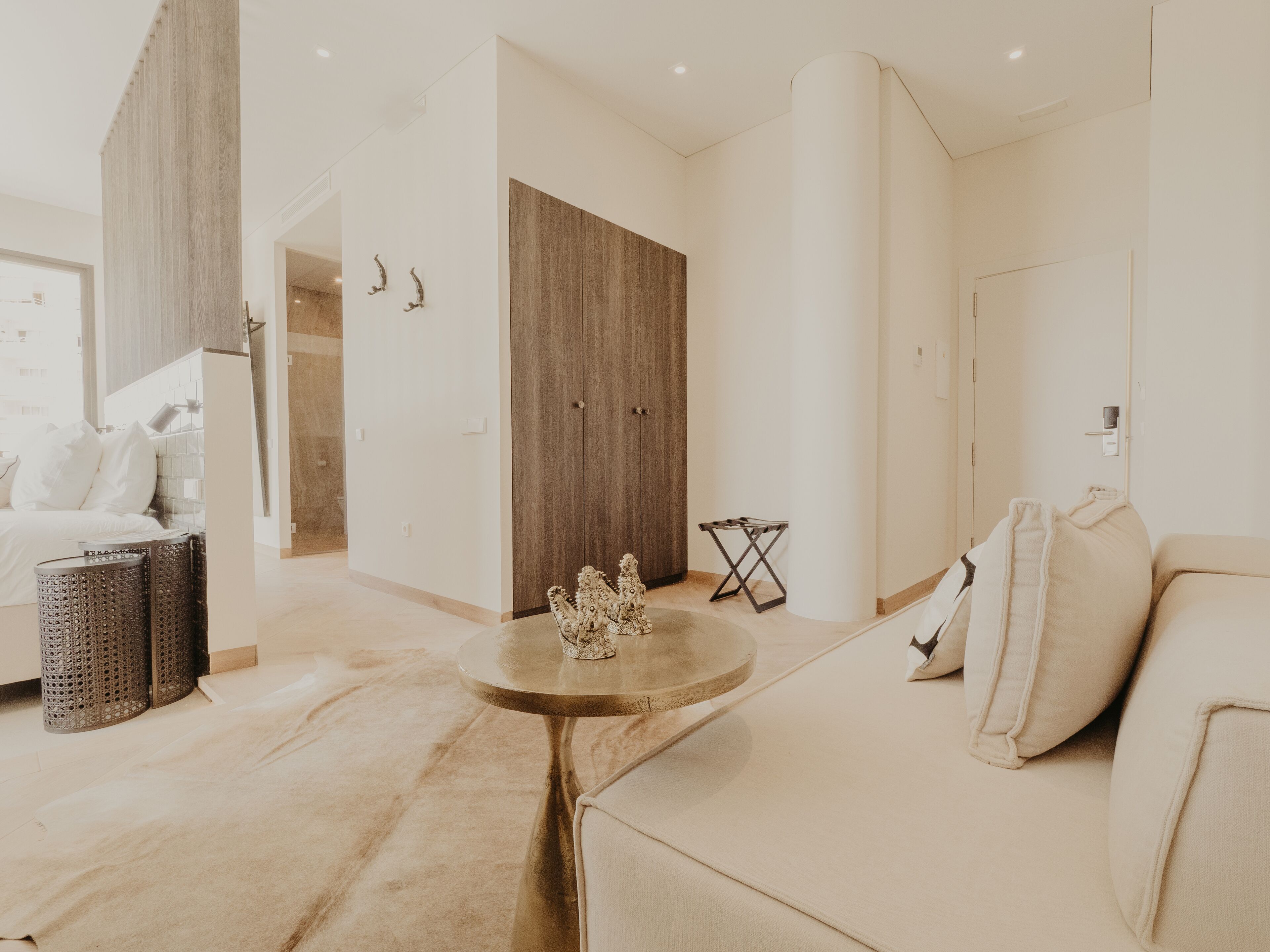 A modern living room with a sofa, a round coffee table, and a wooden wardrobe.