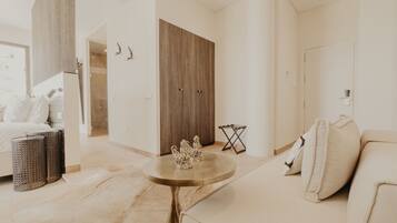 A modern living room with a sofa, a round coffee table, and a wooden wardrobe.