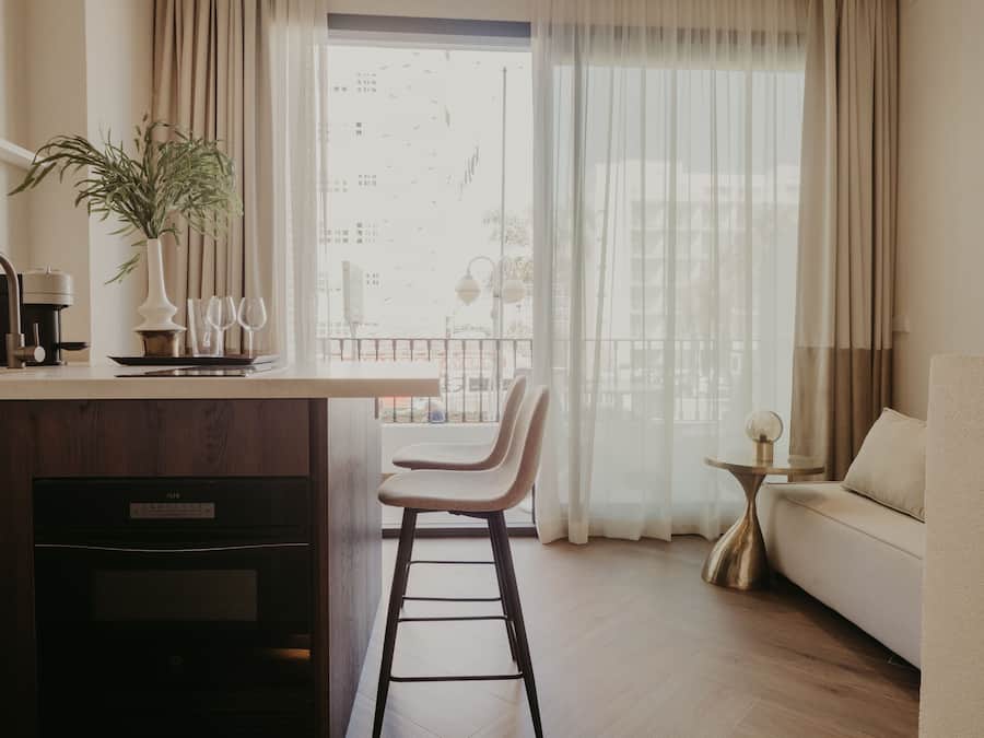 Ein modernes Wohnzimmer mit Küchenzeile, Esstisch und einer Couch.
