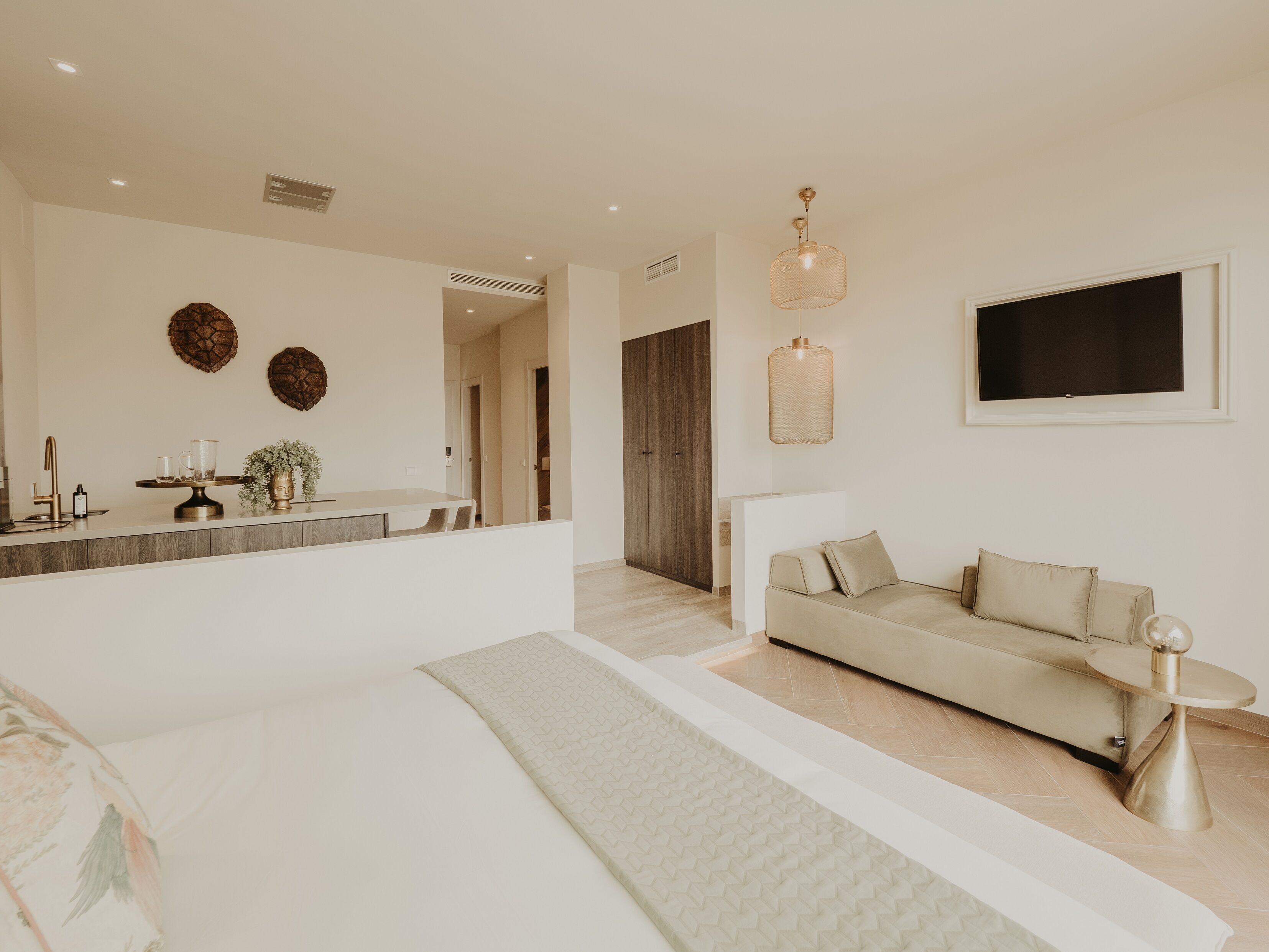 Una sala de estar moderna con un sofá, una mesa de centro y un televisor montado en la pared.
