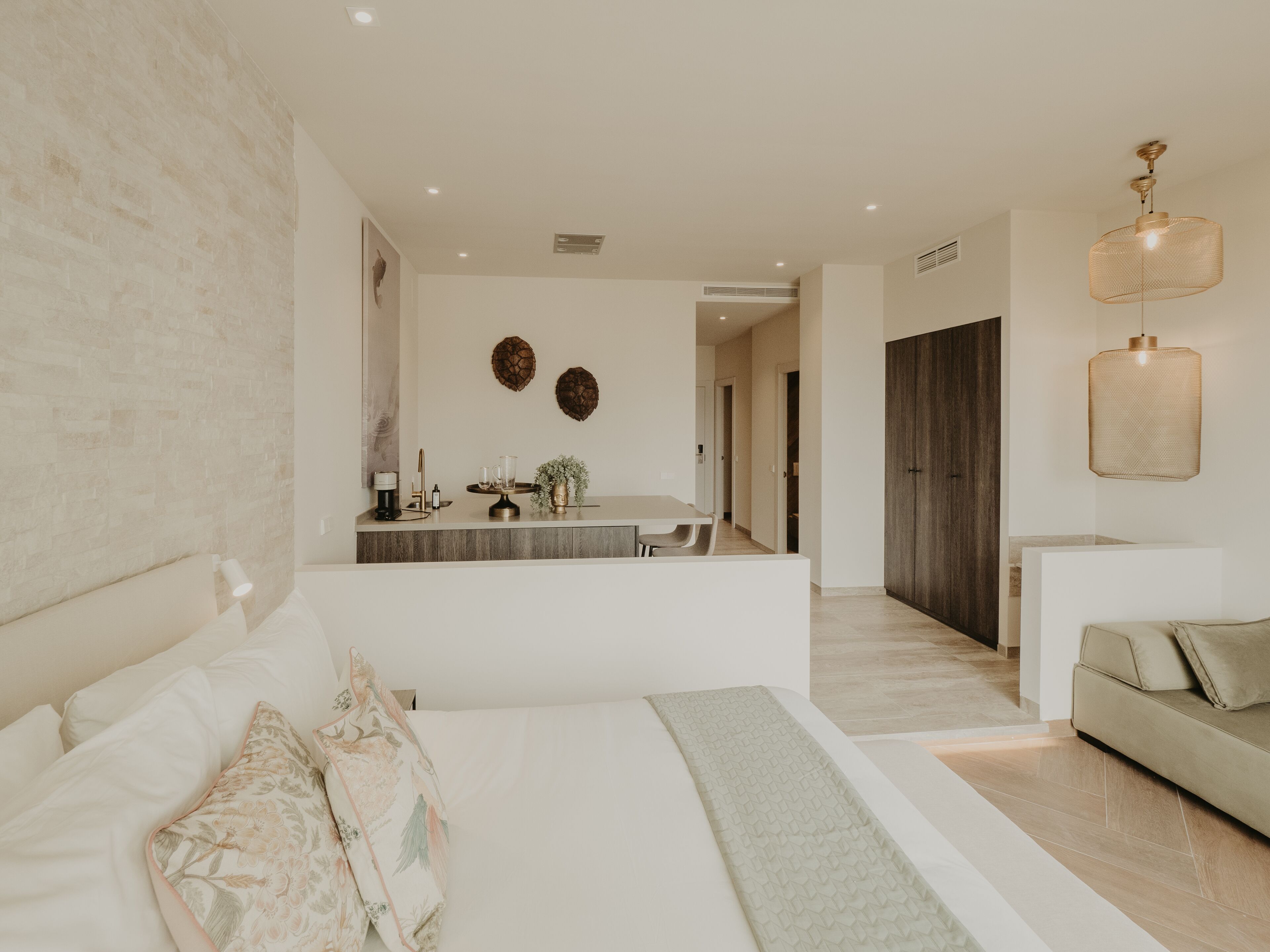 Une chambre à coucher moderne avec un grand lit, une table de chevet, un petit bureau et une armoire.