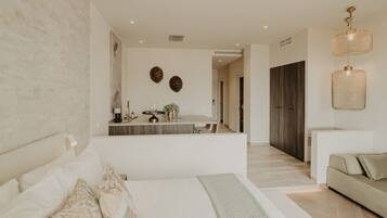 Une chambre à coucher moderne avec un grand lit, une table de chevet, un petit bureau et une armoire.