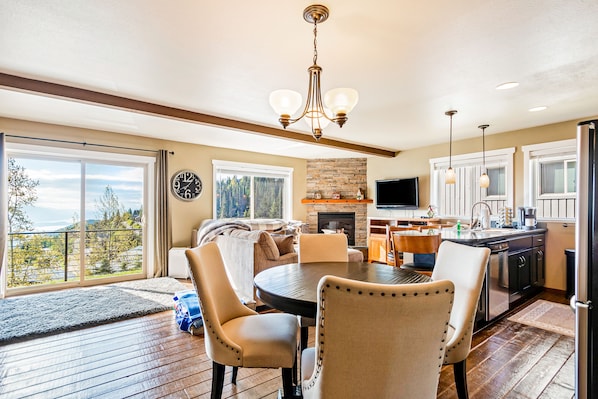 Cozy living space with a round dining table and fireplace, offering a view of the outdoors.