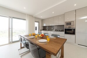 Enjoy meals in the kitchen with appliances and a dining area with a table and breakfast setting.