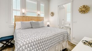 Un dormitorio con cama, mesita de noche y un banco.
