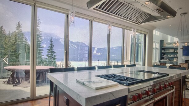 A modern kitchen with large windows, a central island, and a view of mountains. - RMR: Luxury Ski-in/out Mountain-side 4 Bedroom Home (Sleeps 10).  (Revelstoke)