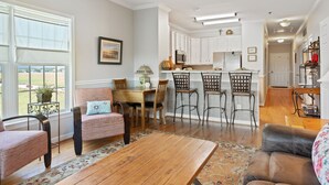 Un salon spacieux avec une table basse en bois, un canapé et un coin repas comprenant une table et des chaises.