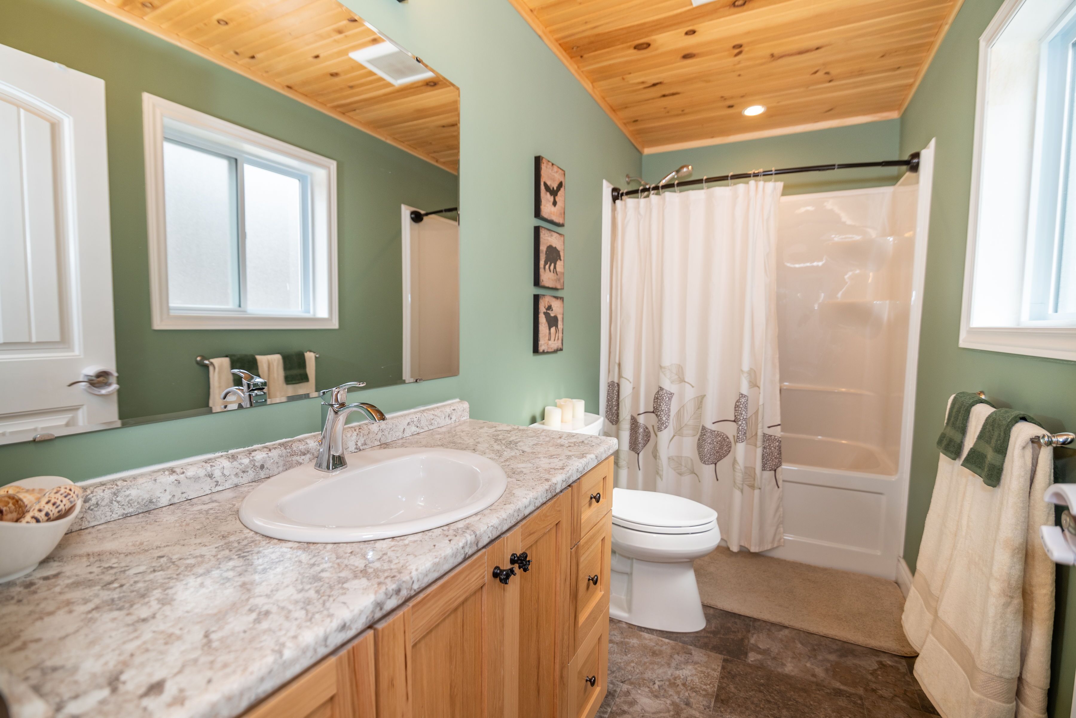 A bathroom with a sink, toilet, and shower.
