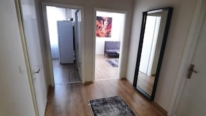 A spacious room with hardwood flooring, a large mirror, and a door leading to a balcony. - PARK BUTİK (Ankara)