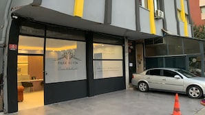 A modern building with a grey facade and yellow accents, featuring a visible entrance with a sign for 'Park Butik'. - PARK BUTİK (Ankara)