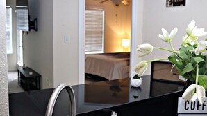 A hotel room with a bed, a ceiling fan, and a nightstand with a lamp. - The Harmony of Buckhead! (Atlanta)