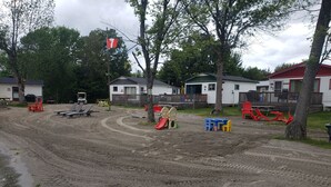 A sandy play area with playground equipment and a flag.