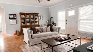 A living room with a sofa, coffee table, and a cabinet. - The Congaree Cottage (Cayce)