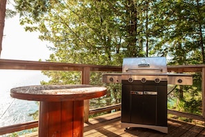 An outdoor grill with a view of the ocean and trees. - The Overlook | Luxury Lakeside Home with Dock (Harrison Hot Springs)