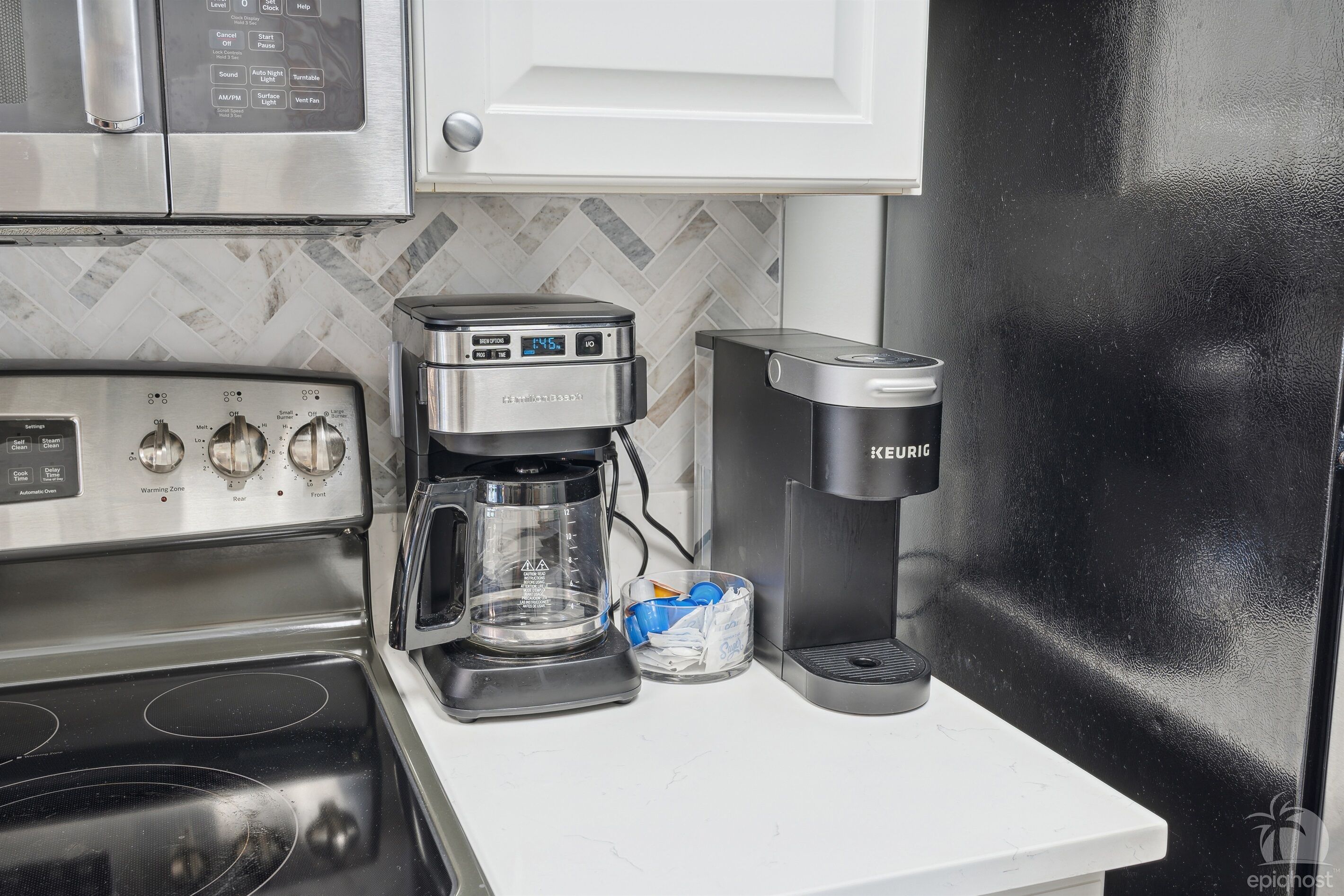 Una cocina con cafetera, una Keurig y microondas.