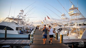 A marina with multiple yachts docked, a wooden walkway, and a clear sky. - BellaVida-Sandestin: Lakefront+Cart to Beach (Miramar Beach)