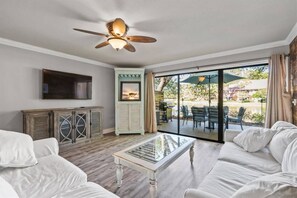 Relax in this inviting living room with a large sliding door to the outdoor patio, flat-screen TV, and comfortable seating area.