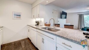 Eine moderne Küche mit weißen Schränken, Granit Arbeitsplatten und einer integrierten Spüle.