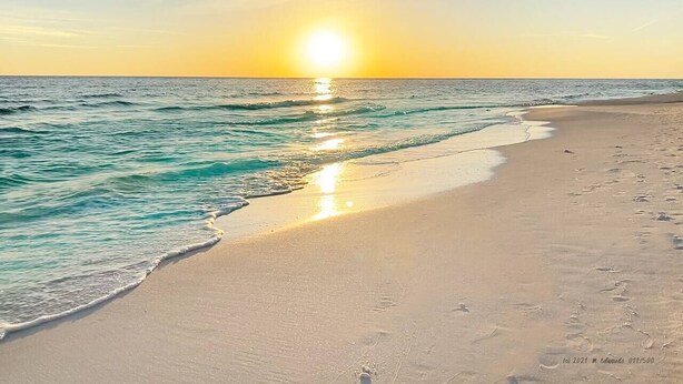 Ein Strand mit einem Sonnenuntergang über dem Meer.