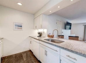 A modern kitchen with white cabinets, granite countertops, and a built-in sink. - MermaidBay-Seagrove: Sleeps 8, Walk to Beach (Santa Rosa Beach)
