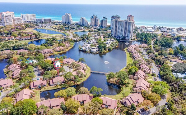 Un quartier résidentiel avec des maisons, un lac et un pont.
