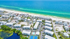 An aerial view of a coastal resort with multiple buildings, a beach, and a swimming pool. - VillaIsla-3BR/2BA Villa - Steps from the Sand! (Santa Rosa Beach)
