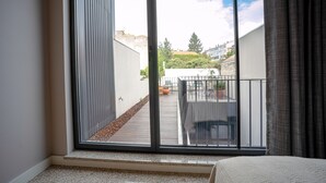 A room with a large sliding glass door leading to an outdoor balcony with a view of a cityscape. - Flores Studio - with terrace (Oporto)