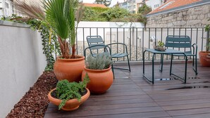 A wooden deck with potted plants and outdoor furniture. - Flores Studio - with terrace (Oporto)