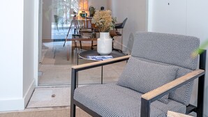 Un salon moderne avec un canapé à motifs, une table basse et un coin repas comprenant des chaises et une table.