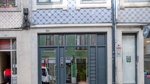 Un bâtiment dont la façade présente un motif bleu et blanc, avec une devanture visible et une plaque de rue indiquant « CASA DE SANTA CRUZ ».