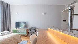 A modern hotel room with a bed, a TV, a desk, and a bathroom mirror. - Sá da Bandeira Studio - with balcony (Oporto)