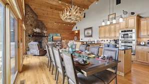 A spacious dining area with a wooden table set for a meal, surrounded by chairs. - Amazing Views*HotTub*Sauna*GameRooms Dog-friendly! (Beech Mountain)