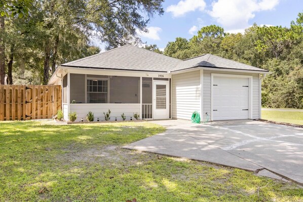 A single-story house with a garage, a covered porch, and a fenced yard. - Beautiful 3 Bedroom Home in Quiet Neighborhood (Gainesville)