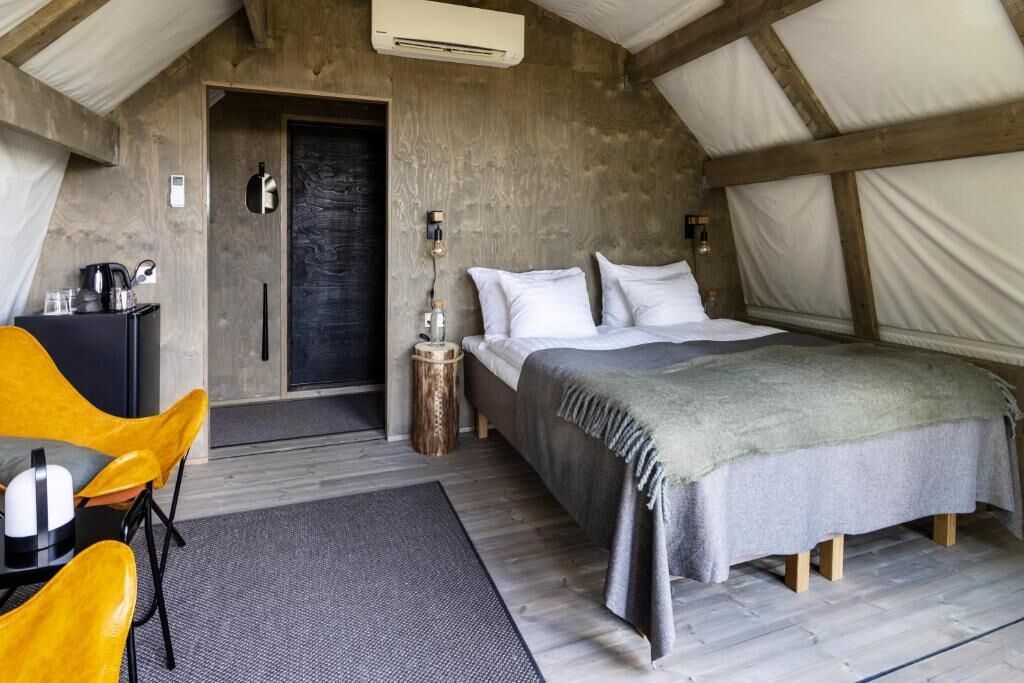 Un dormitorio acogedor con cama, mesita de noche y una silla.