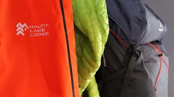 A close-up of a bright orange jacket with the text "HALTIA LAKE LODGE" on it.