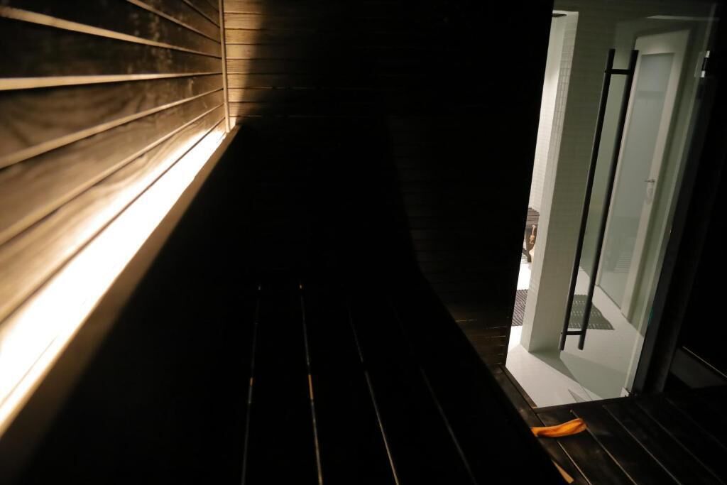 A narrow, dimly lit hallway with wooden paneling on one side and a door at the end.