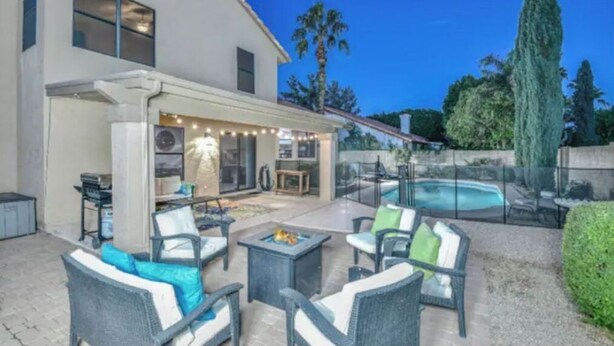Una casa moderna con patio coperto, area relax esterna e piscina.