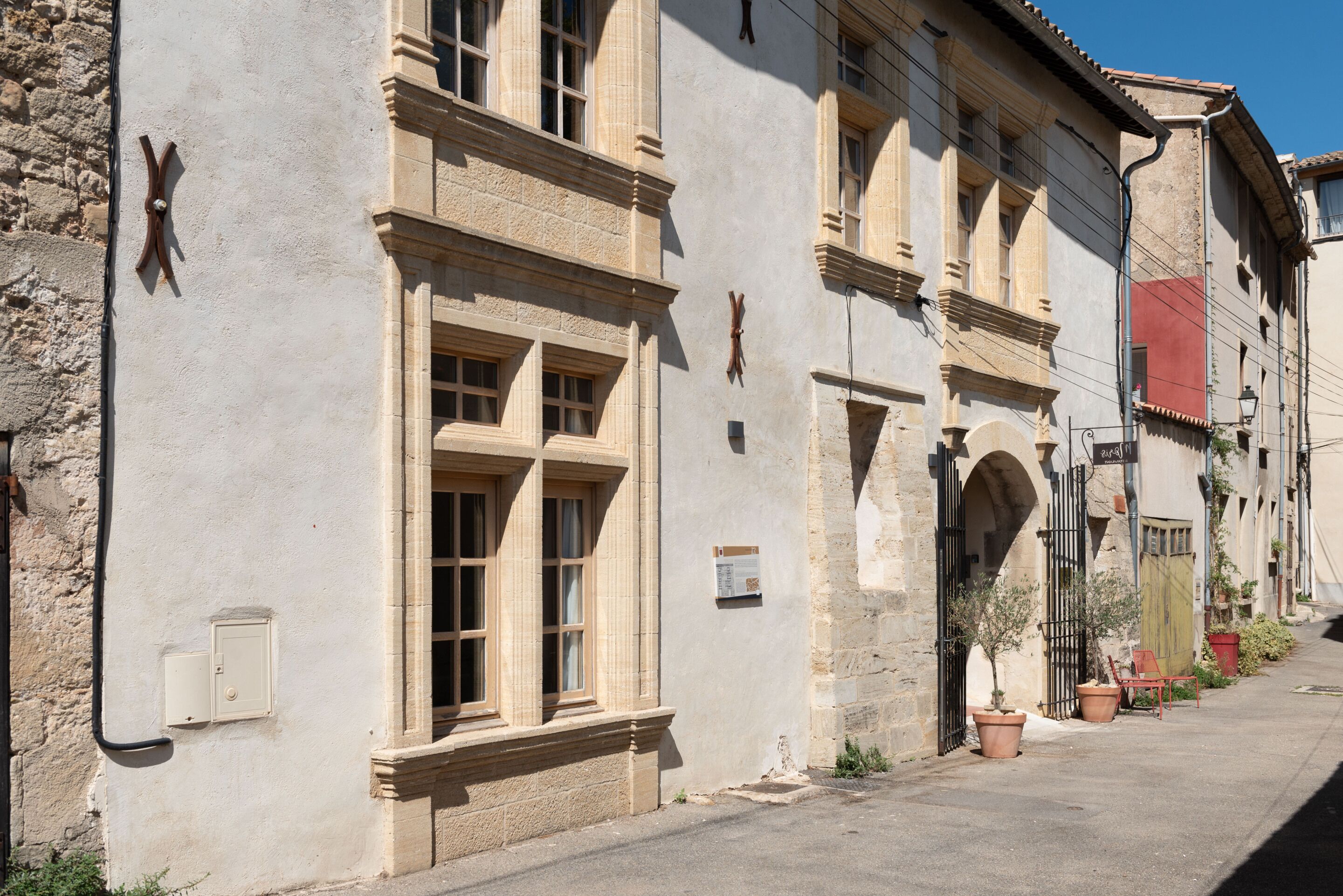 Un bâtiment historique doté de grandes fenêtres et d’une façade en pierre.
