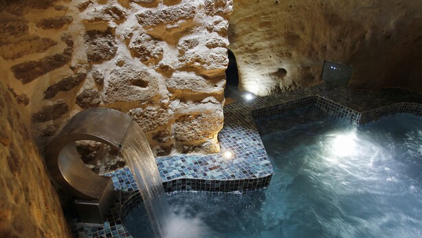 A stone-walled hot tub area with a tiled floor and a water feature. - La Maison des Seigneurs (Cucuron)