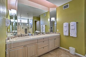 A bathroom with a double sink vanity, a large mirror, and two towels hanging on the wall. - Upstairs suite, overlooking the pool (Cathedral City)