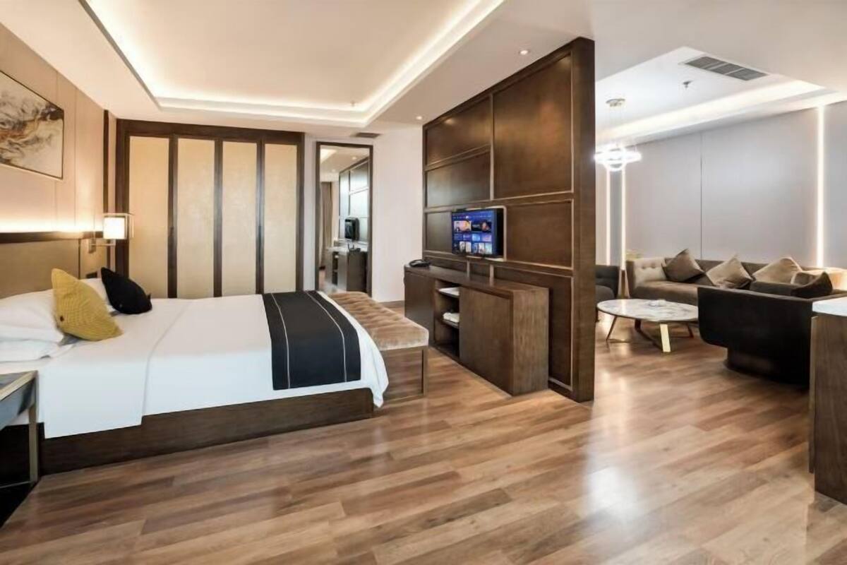 Una habitación de hotel moderna con cama, escritorio, sofá y televisor.