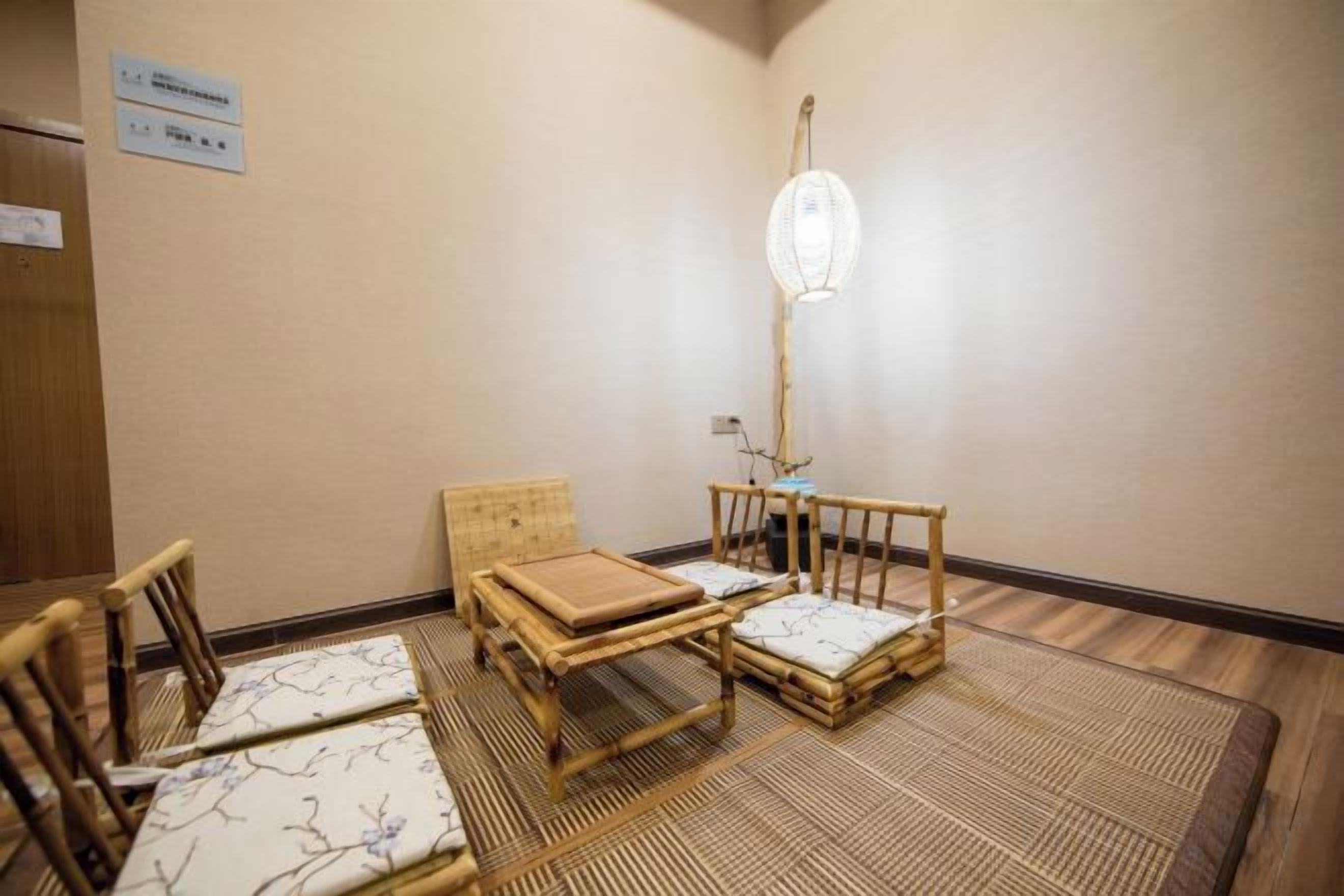 Una habitación con suelo de esteras tatami, una mesa baja con cojines y un farolillo japonés tradicional.