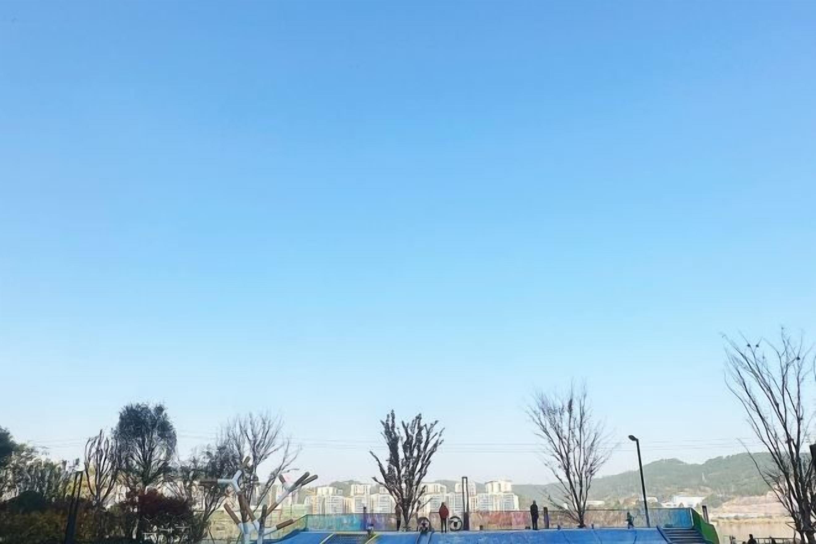 Cielo azzurro intenso con vista su un edificio e alberi.